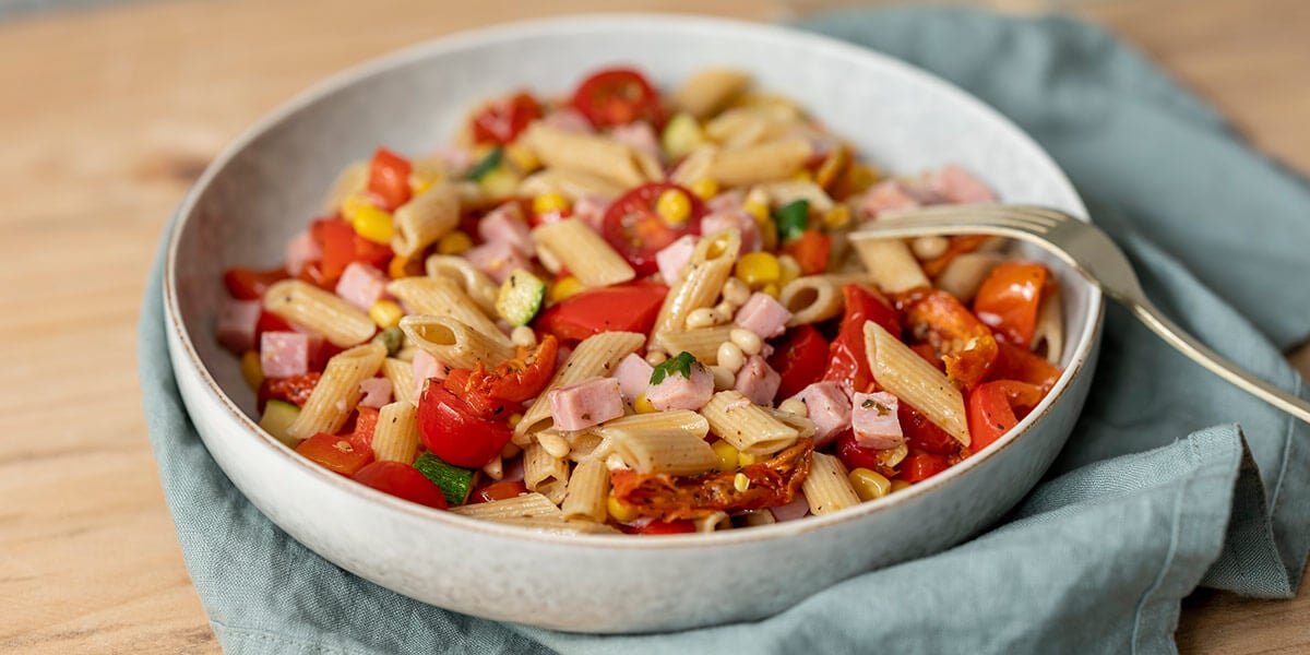 Lauwe pastasalade met paprika, maïs en hamblokjes