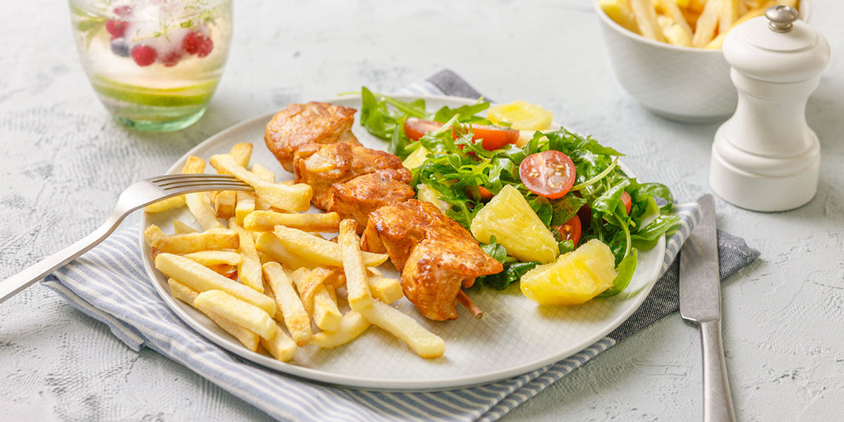 Kipbrochettes met ananassalade en verse ovenfrietjes