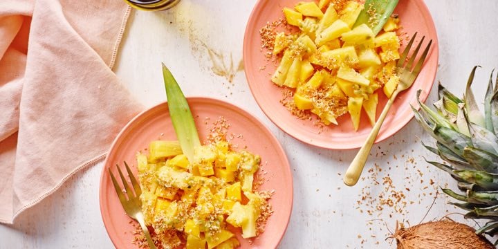 Tropische fruitsla met mango, ananas, passievrucht en geroosterde kokos