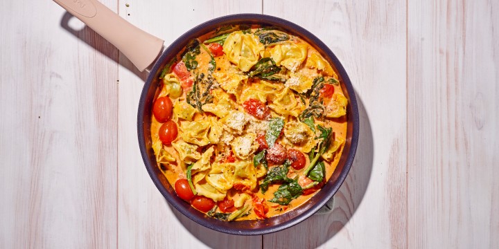 Tortellini pesto met tomatensaus en basilicum
