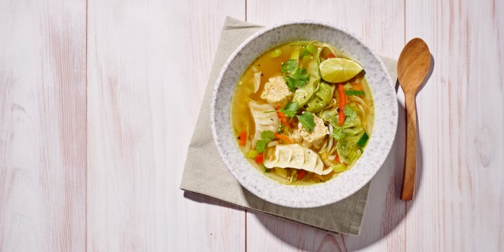 Soep met dim sum, groenten, koriander en limoen