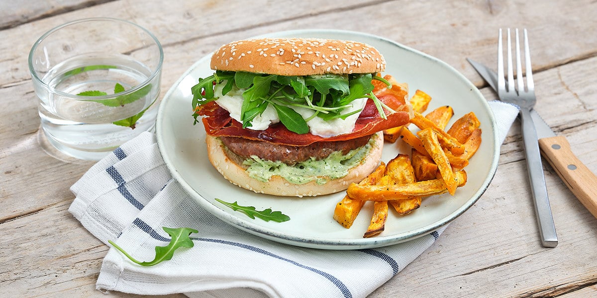 Hamburger met krokante ham, mozzarella, pestomayo en ovenfrietjes
