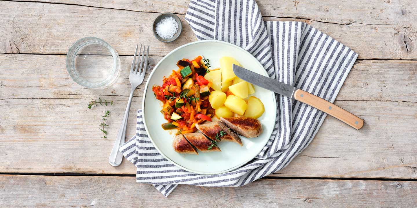 Gebakken boerenworst met ratatouille en gekookte aardappelen