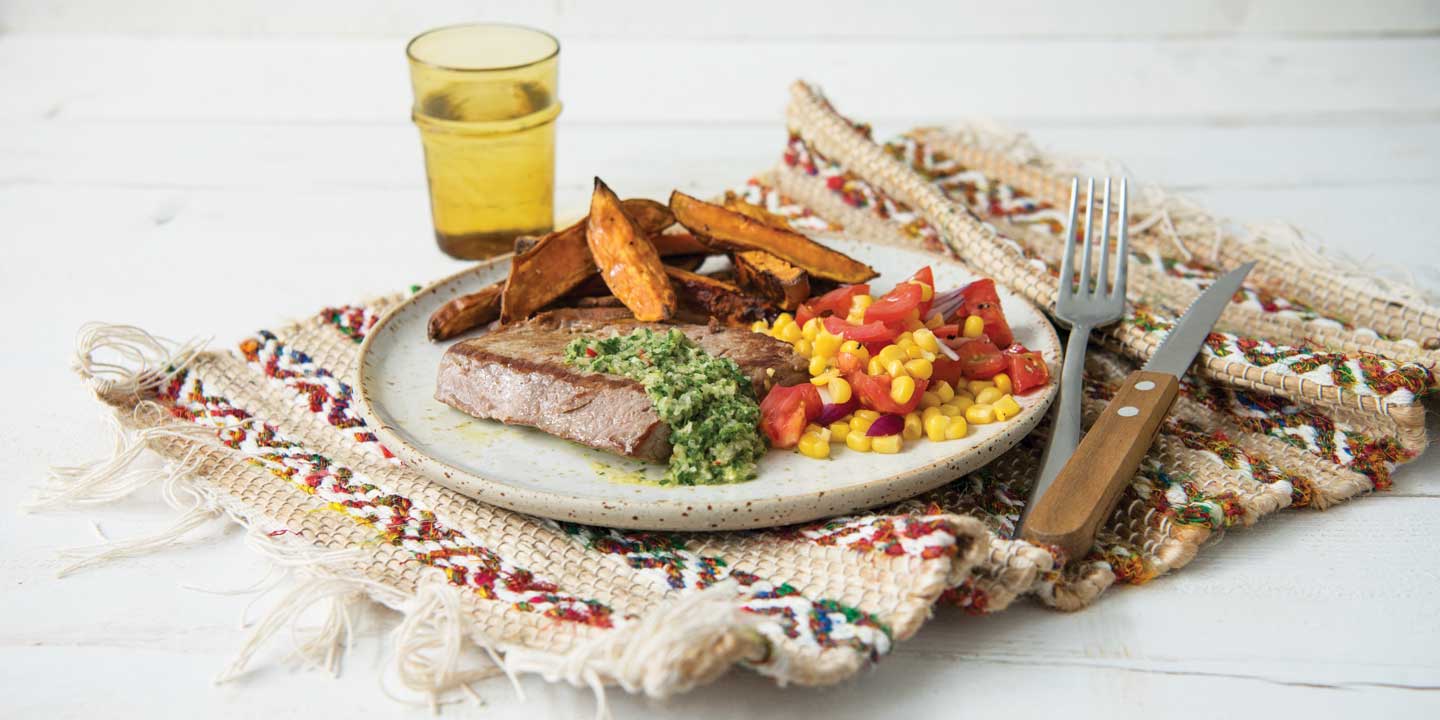 Steak met chimichurri, zoete aardappelfrietjes en tomaten- maïssalade