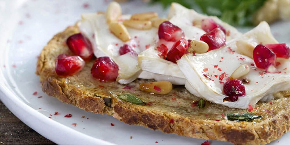 Fijne sneetjes toast biaform met geitenkaas en granaatappel