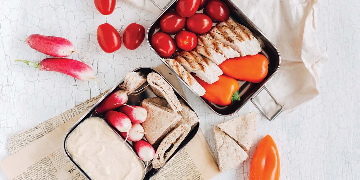 Bento box met hummus, kip en groenten en met pitabroodjes