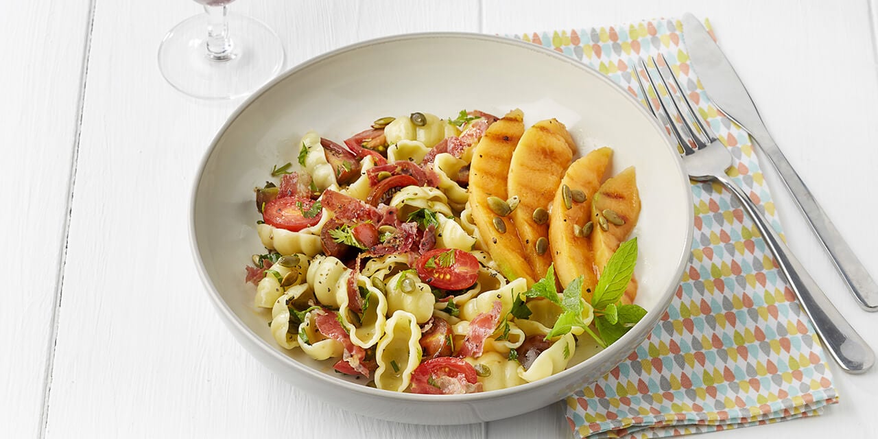 Pastasalade met verse kruiden, knapperige pancetta en gebakken meloen