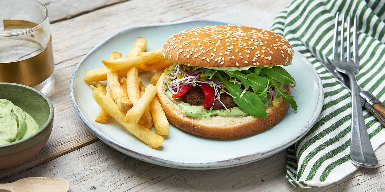 Vegetarische burger met avocadosaus, geroosterde paprika en ovenfrietjes